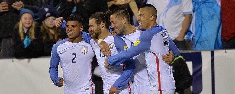 USA players celebrate in front of Jurgen Klinsmann