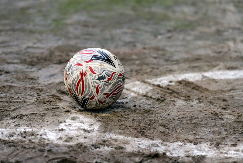 soccer ball on muddy pitch